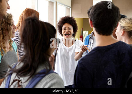 Students chatting together in school corridor Stock Photo