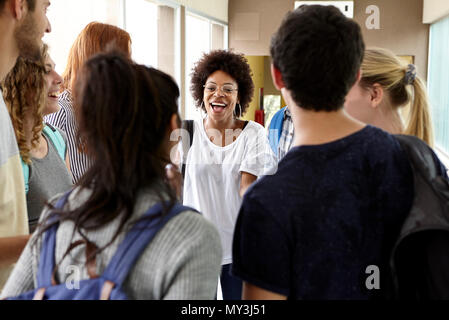Students chatting together in school corridor Stock Photo