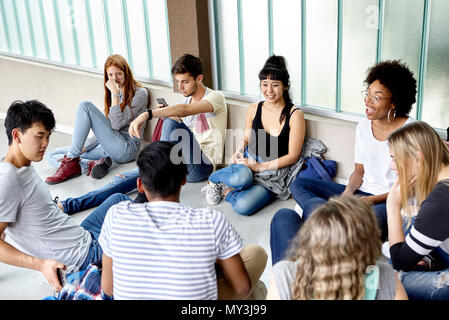 Group of students hanging out together in corridor Stock Photo