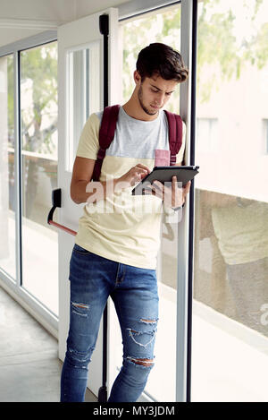 College student looking at digital tablet between classes Stock Photo