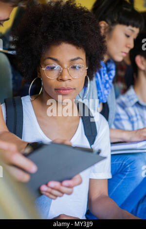 College student looking at classmates digital tablet Stock Photo
