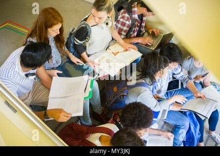 Group of students studying together in stairwell Stock Photo