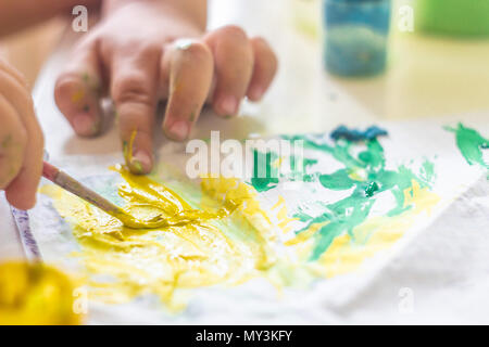 A small child draws paints on a table. Stock Photo