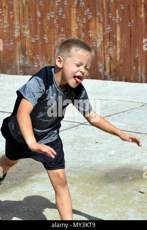 boy playing in bubbles Stock Photo