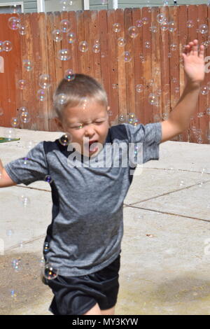 boy playing in bubbles Stock Photo