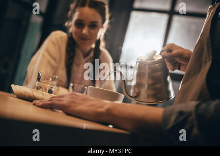 selective focus of man pouring hot water into bowl with grind coffee Stock Photo