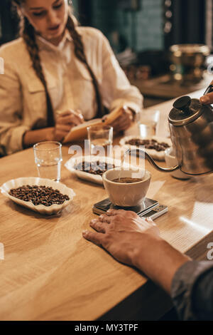 selective focus of man pouring hot water into bowl with grind coffee Stock Photo