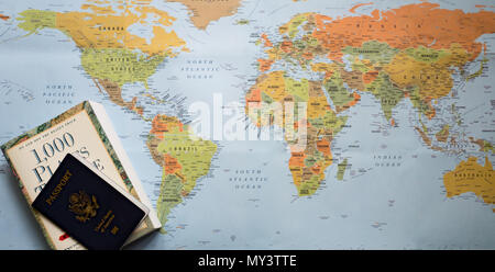 A world map with a travel planning book and U.S. passport. Photographed from above. Stock Photo