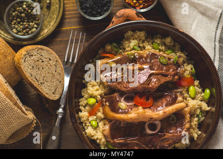 Roasted Lamb Loin Chops with Couscous and Soybean in Rustic Clay Dish Stock Photo