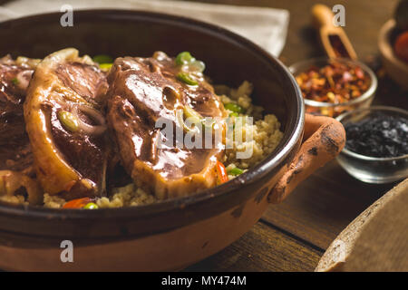 Roasted Lamb Loin Chops with Couscous and Soybean in Rustic Clay Dish Stock Photo