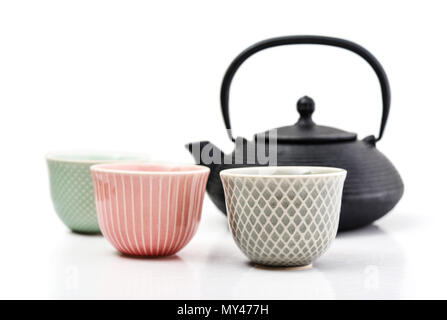 Green tea in cast-iron teapot with small cups on light background Stock Photo