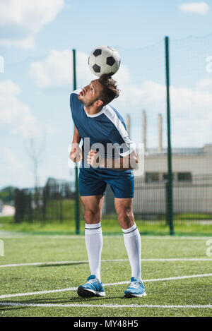 focused soccer player training with ball on soccer pitch Stock Photo