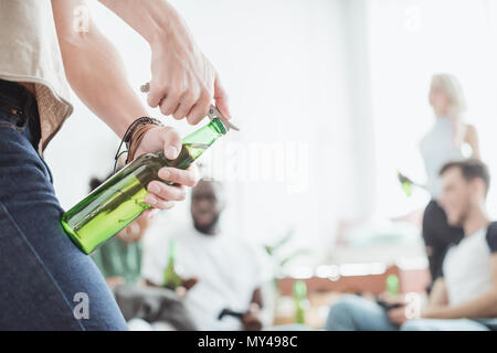cropped image of man opening beer bottle by corkscrew Stock Photo