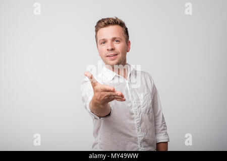 Caucasian man in white shirt shaking hands isolated on white background. Stock Photo