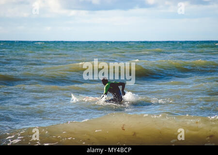 Zelenogradsk, Russia-may 17, 2016: A lone surfer trains on small waves in the Baltic sea Stock Photo
