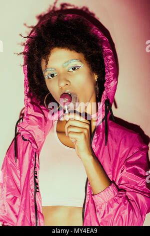 fashionable african american girl posing in 80s style clothes with