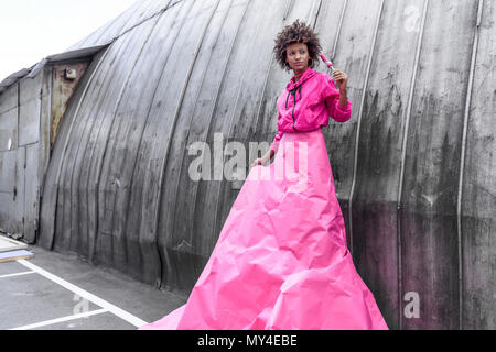 fashionable african american girl holding popsicle and posing in pink paper Stock Photo