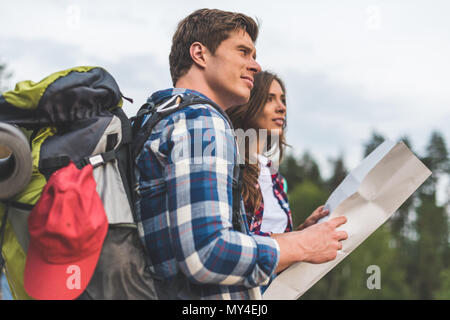 thoughtful active couple of hikers with map looking away Stock Photo