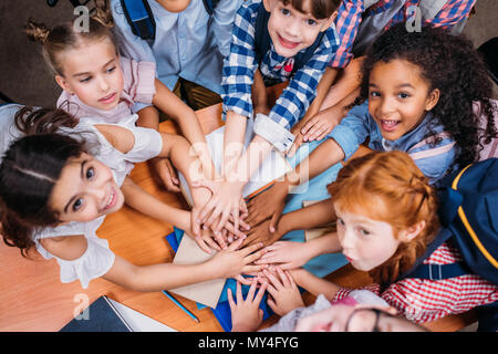 top view of team of adorable kids making team gesture Stock Photo