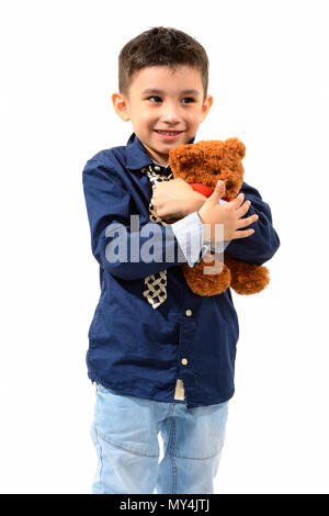 Studio shot of cute happy boy smiling and hugging teddy bear wit Stock Photo