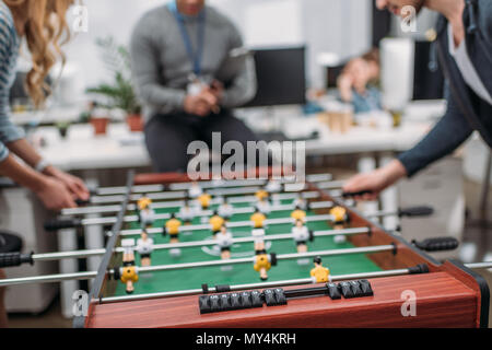 cropped image of people playing in table soccer at modern office Stock Photo