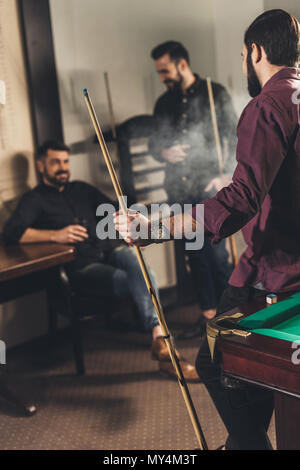 company of happy men with drinks and cues at billiard bar Stock Photo