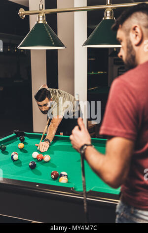 couple of young successful handsome men playing in pool at bar Stock Photo