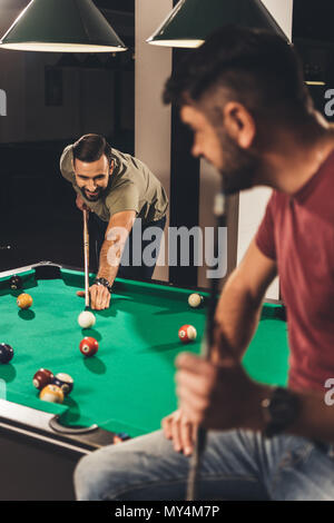couple of young successful handsome men playing in pool at bar Stock Photo