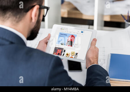 businessman holding tablet with loaded ebay page Stock Photo