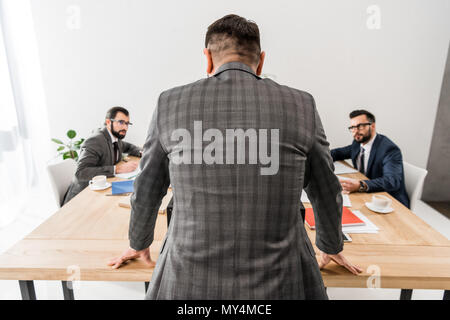 rear view of team leader standing and looking at workers Stock Photo
