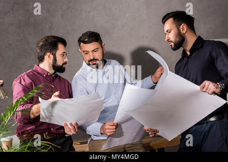architects looking at blueprints and discussing work Stock Photo