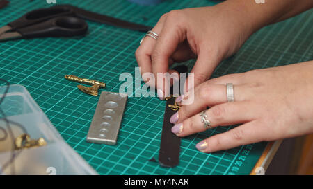 Tanner marks place for fixing decoration on leather product. Process of working in workshop close-up. Stock Photo