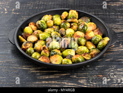 Fried brussels sprouts on portion of frying pan and table Stock Photo