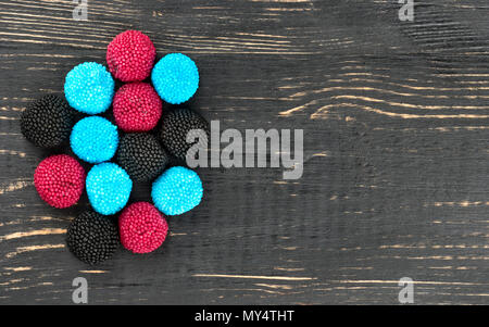 Several multi-colored berry jelly candies on a blank wooden background, top view Stock Photo