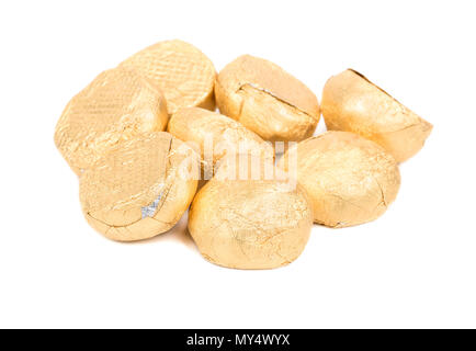 Pile chocolate candies wrapped in gold on a white background Stock Photo