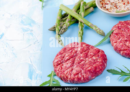 Meat cutlets for grilling and asparagus. Protein food. Place for text. copy space Stock Photo
