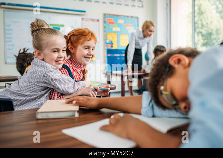 beautiful schoolgirls laughing of sleeping classmate in class Stock Photo