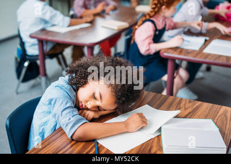 exhausted african american schoolgirl sleeping in class Stock Photo
