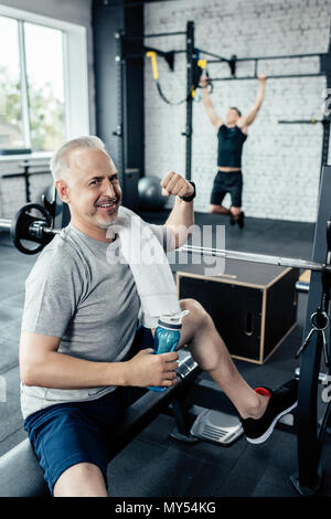 senior sportsman with sport bottle gesturing in gym Stock Photo