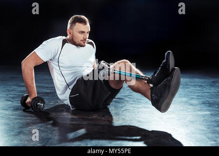 side view of  sportsman with dumbbell doing push ups Stock Photo
