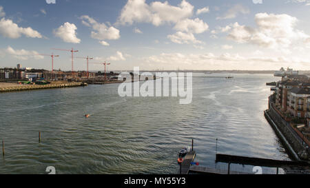 The River Itchen flows into Southampton Water between apartment buildings and construction sites in the city of Southampton. Stock Photo