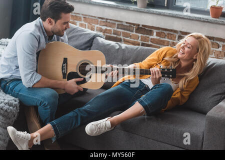happy young couple having fun while fighting for guitar Stock Photo