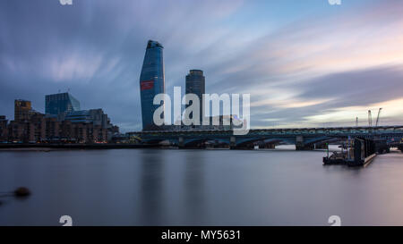 London, England, UK - April 3, 2018: The River Thames flows under Blackfriars railway station, with the South Bank skyline behind at sunset. Stock Photo