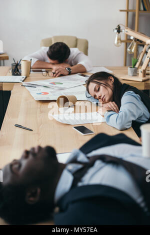 group of businesspeople sleeping in conference hall at office Stock Photo