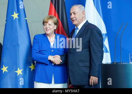 04.06.2018, Berlin, Israel's Prime Minister Benjamin Netanyahu and Chancellor Angela Merkel shake hands with the national flags of Israel and Germany after the press conference in the Chancellery. | June, the 4th 2018, Berlin, Israel Prime Minister Benjamin Netanyahu and the German Federal Chancellor Angela Merkel shaking hands after the press conference at the Chancellery in front of the ensigns of Israel and Germany. | usage worldwide Stock Photo
