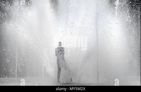 Frankfurt, Germany. 06 June 2018, Germany, Frankfurt am Main: An adolescent standing amid the water fountains of the Walther-von-Cronberg-Platz in the district of Sachsenhausen. Photo: Arne Dedert/dpa Credit: dpa picture alliance/Alamy Live News Stock Photo