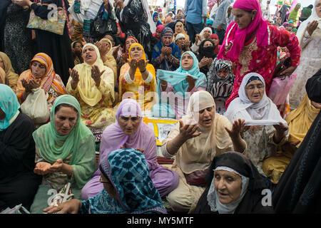 Kashmiri Muslim women devotee prays, at Hazratbal shrine to mark the death anniversary of Imam-e- Ali, the cousin and the son-in-law of the Prophet Muhammad in Srinagar, the summer capital of Indian administered Kashmir, India. Muslims from all over Kashmir visit the Dargah shrine in the Hazratbal area of Srinagar to mark the death anniversary of Caliph, cousin and the son-in-law of the Prophet Muhammad. The shrine is highly revered by Kashmiri Muslims as it is believed to house a holy relic of the Prophet Mohammed. The relic is displayed to the devotees on important Islamic days. The Muslims  Stock Photo