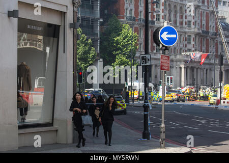 London, UK. 6th June, 2018. Members of the public are shepherded away from a fire at the 12-storey Mandarin Oriental hotel in Knightsbridge. London Fire Brigade advised that 20 fire engines and around 120 firefighters and officers were tackling the fire on the roof of the hotel. Credit: Mark Kerrison/Alamy Live News Stock Photo