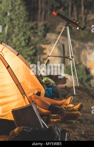 couple relaxing in tent on hiking trip at night Stock Photo