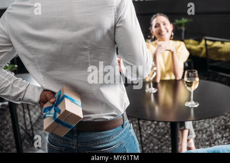 cropped shot of man hiding gift for girlfriend behind back Stock Photo